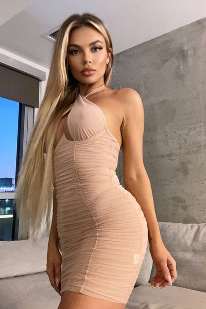 woman wearing a beige sheer halter mini dress