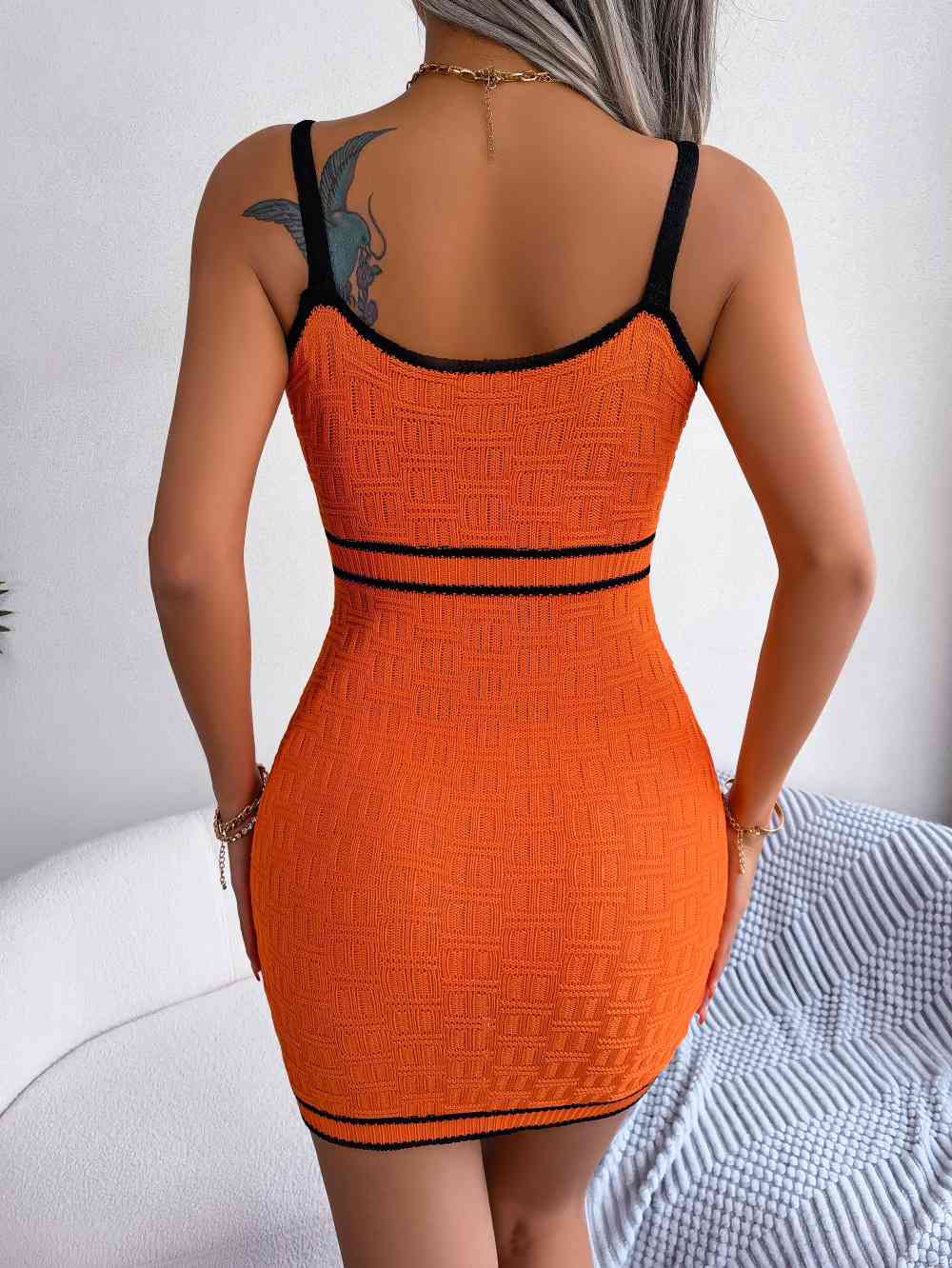 woman wearing a contrast trim cutout knit orange sweater dress