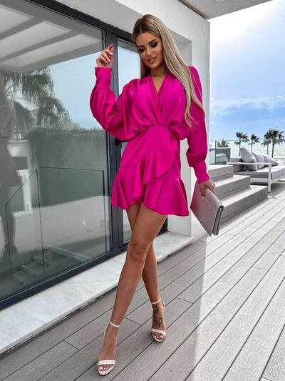 woman wearing a pink v neck ruffle mini dress