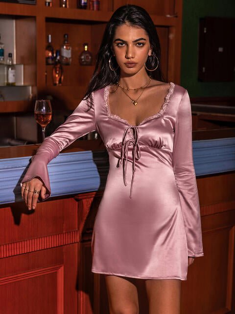 woman wearing a pink satin long sleeve mini dress